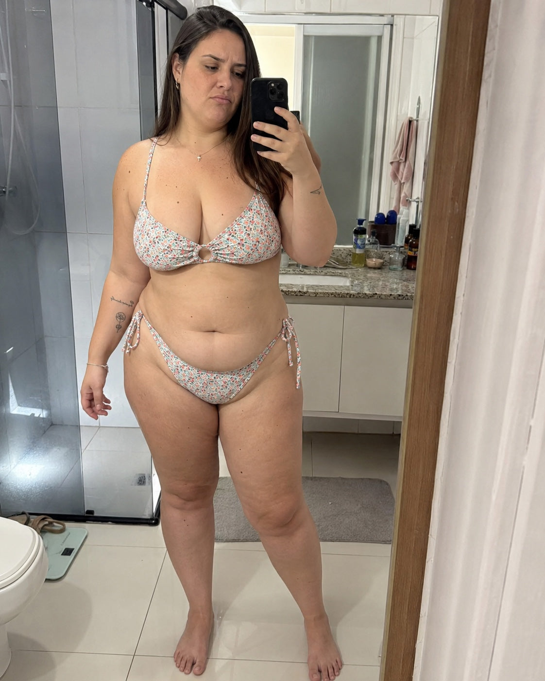 Mulher diante do espelho usando biquíni